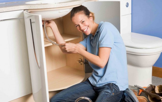 women repairing a sink